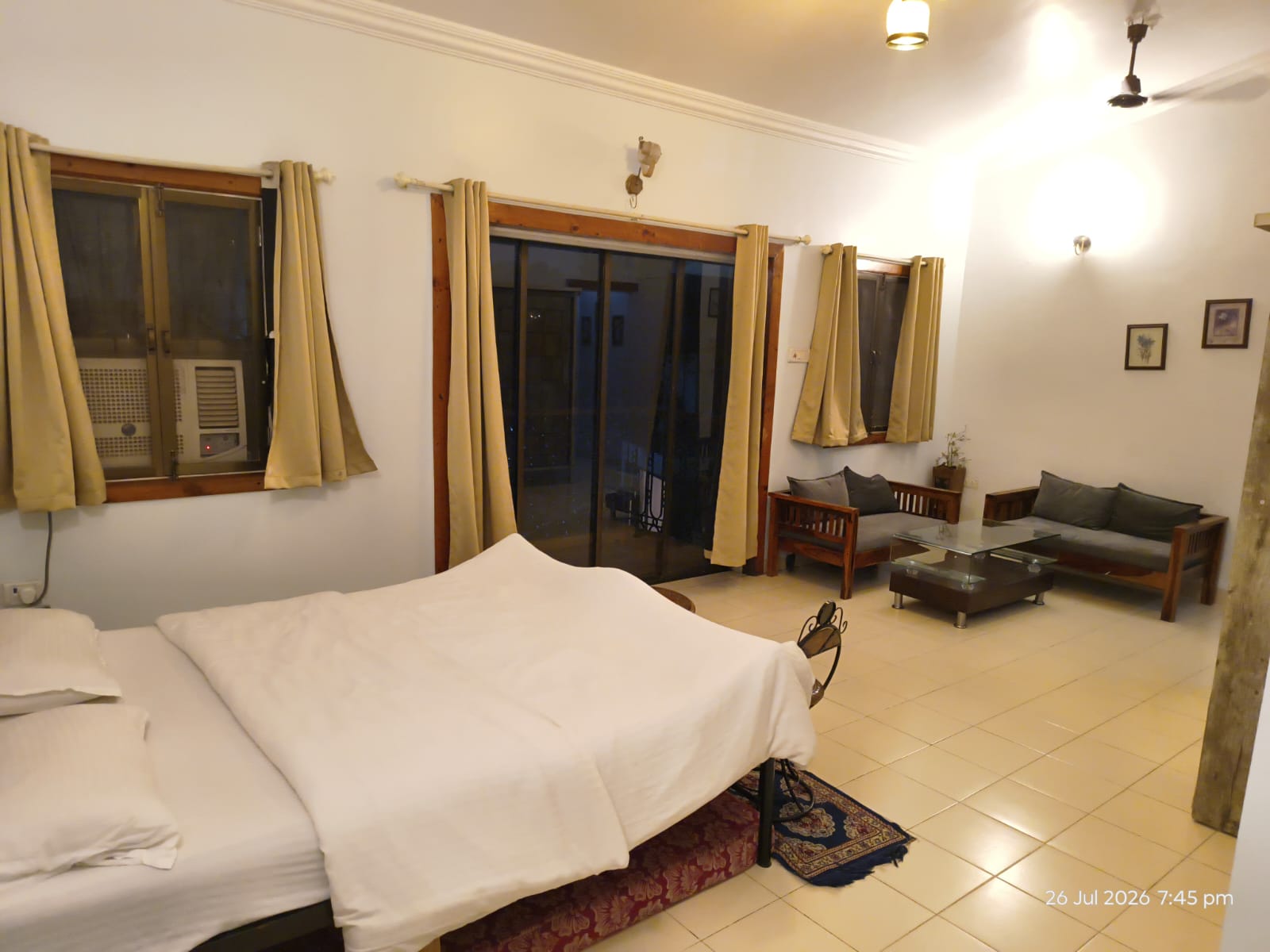 Air-conditioned bedroom with carved wooden headboard at the 3.5 BHK villa in Lonavala